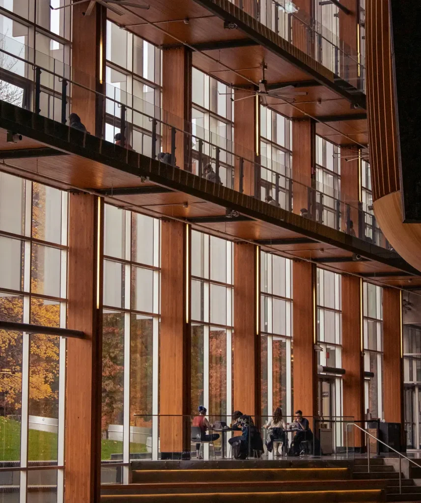 Bild inifrån en kontorsbyggnad. På bilden ses människor sitta och arbeta vid bord.