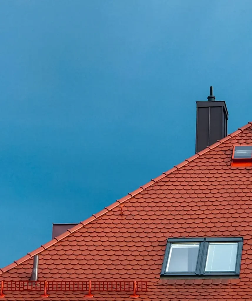 En fin bild av en blå i himmel och en del av ett tak till ett lägenhetshus.