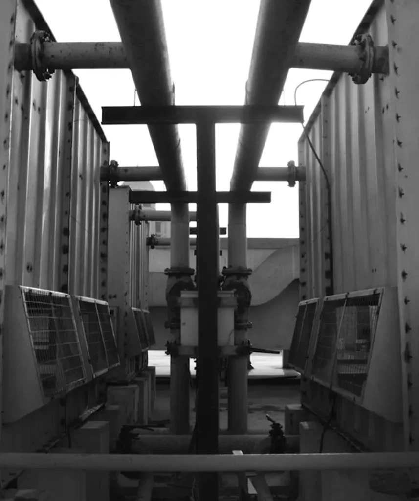 En bild på rör och fläktar i en industriell miljö.