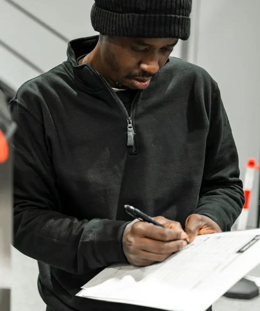 En man som kontrollerar ett jobb och checkar av en checklista.